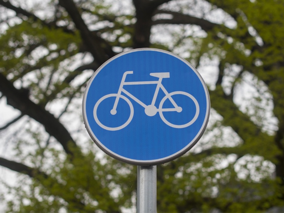 Man sieht ein Verkehrsschild, das einen Radweg anzeigt.